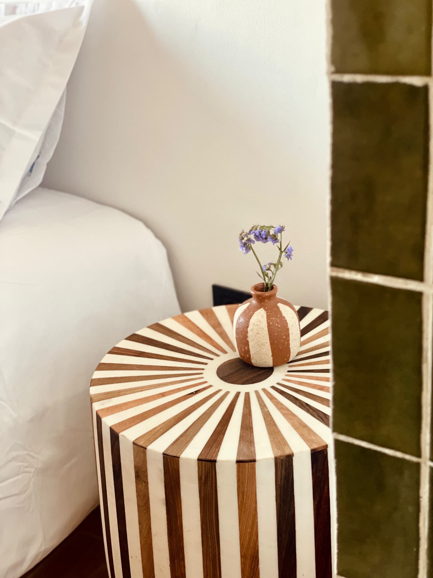 Table d'appoint en marqueterie de bois et petit vase en terre cuite avec fleurs violettes
